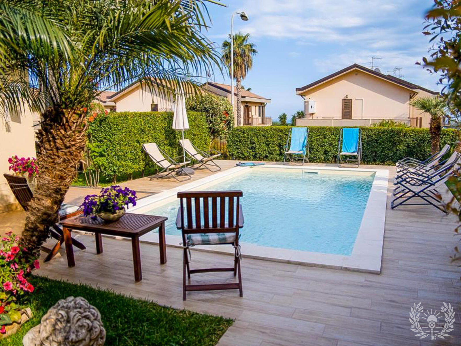 Piscina con palme e lettini